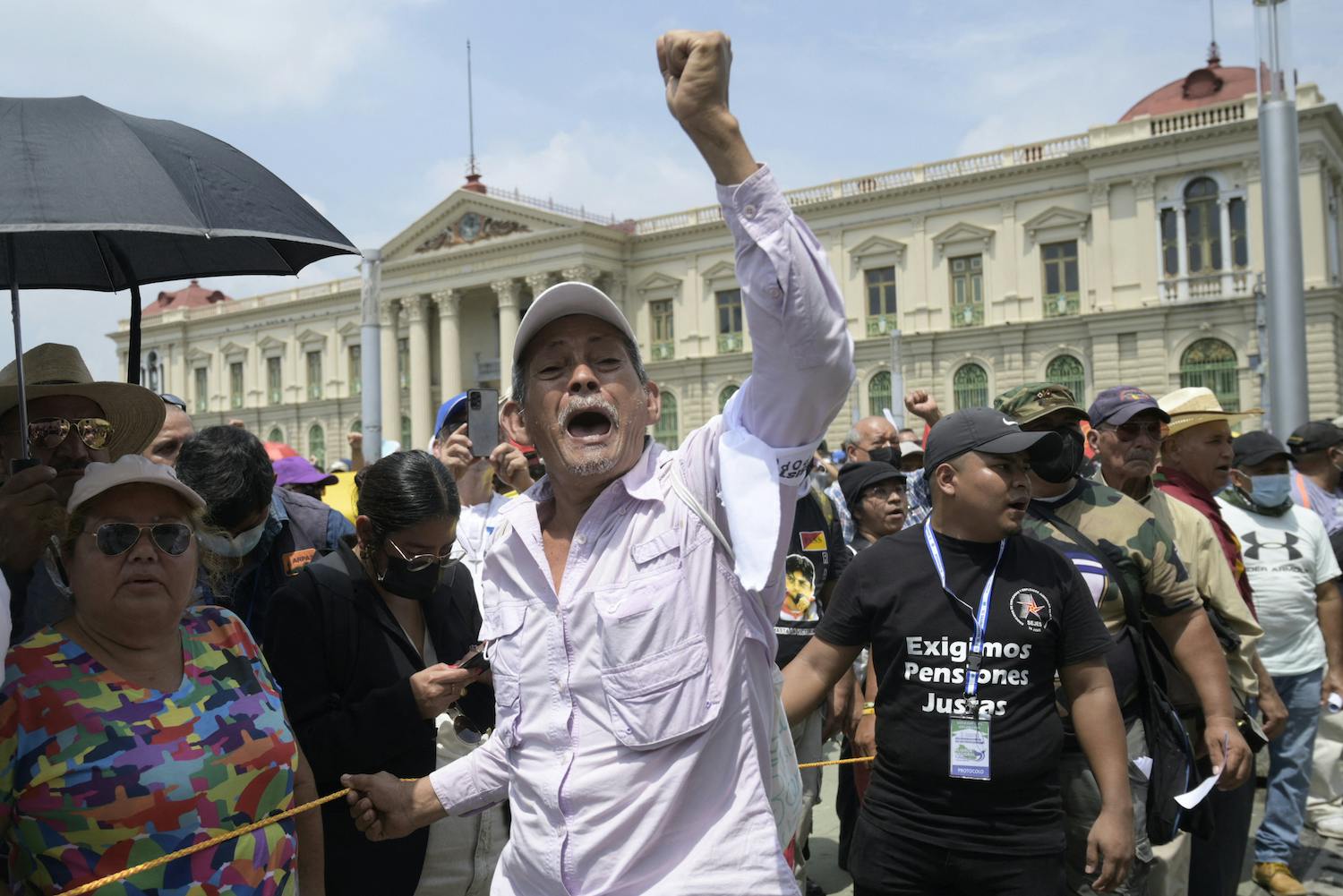 man with his fist in the air at a protest in El Salvador